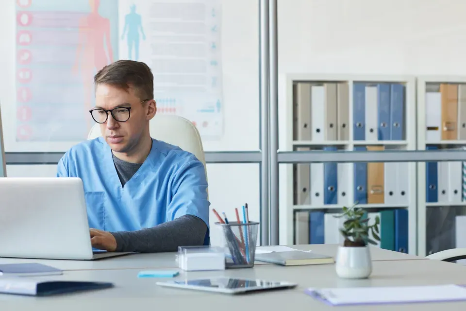 Medical Office Assistant Working on Computer in Clinic